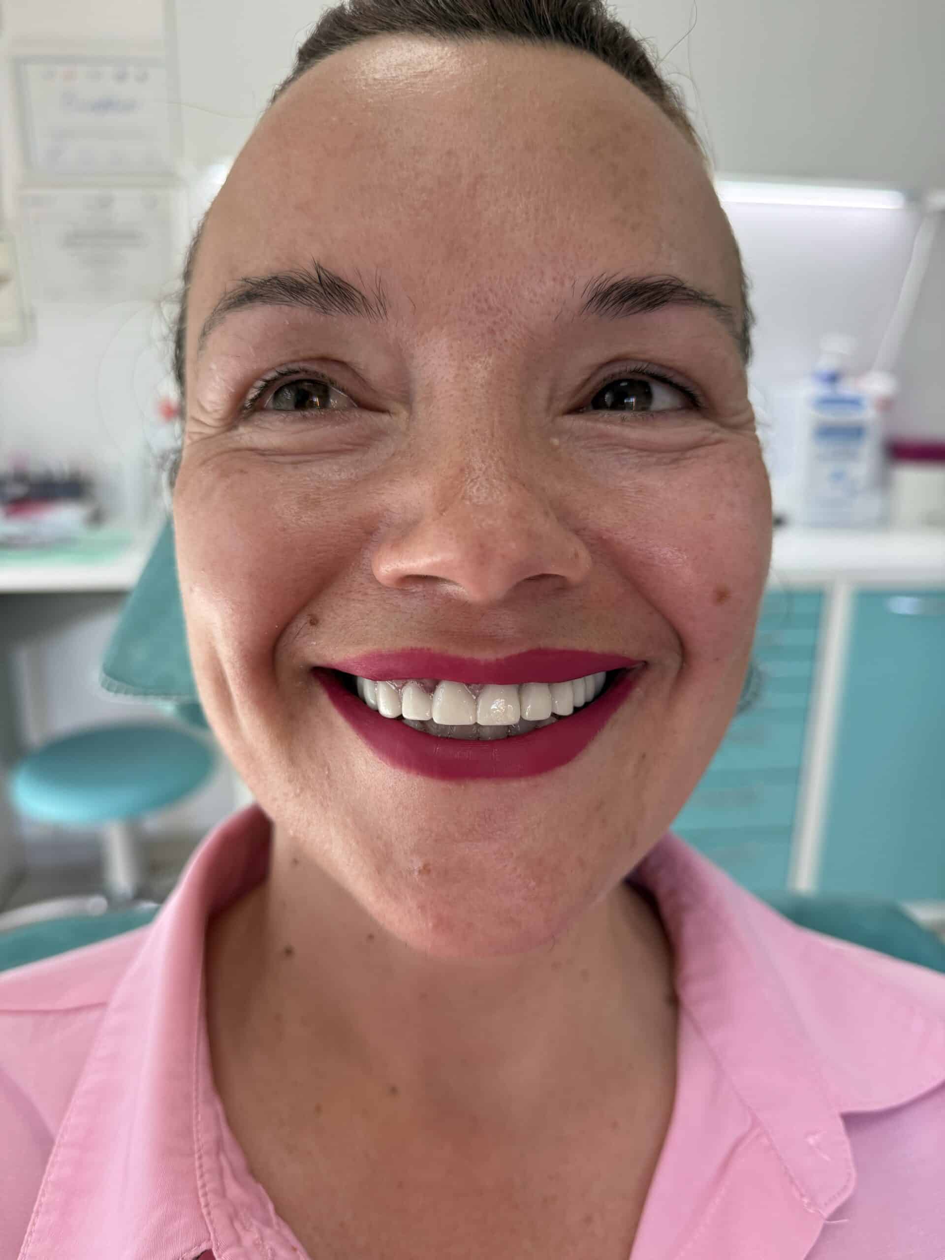 Happy woman with a bright smile in a dental clinic setting.